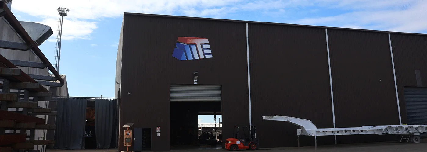 The Modern Transport Engineers workshop in Hamilton, with a heavy transport trailer outside